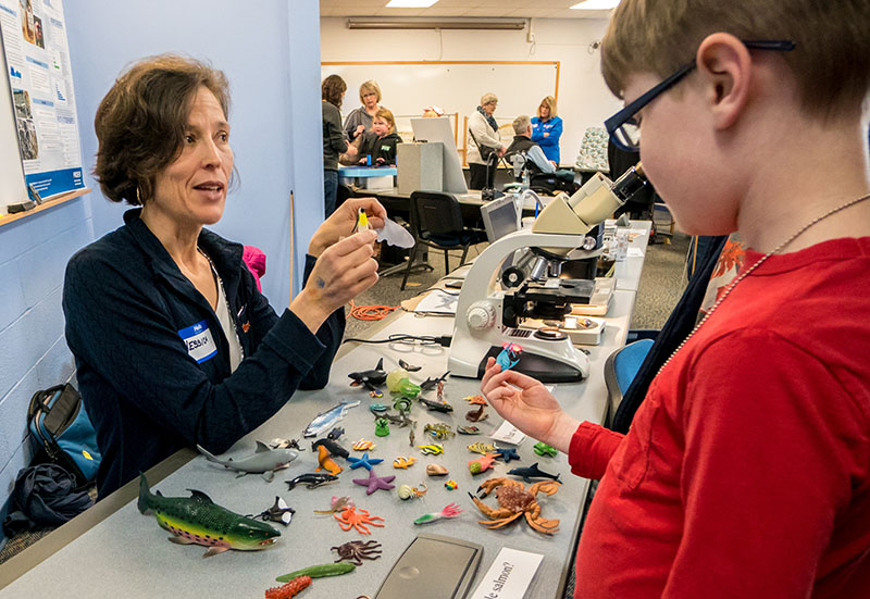 COMES faculty member Jessica Miller talks to a child on Marine Science Day.